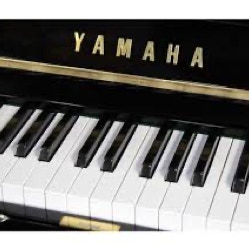 A vintage black upright piano with music sheets and framed photos in a cozy room.